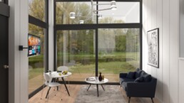 Ett rum med stora fönster med tv och bord från Attefallhus 30 kvm modell Louise