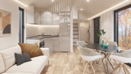 En ljus soffa och ett kök i ljusa färger inne i ett fritidshus